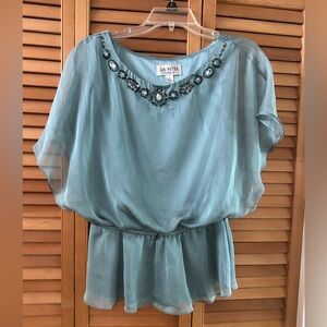 Beaded evening blouse made of sheer material. It is a beautiful teal color.